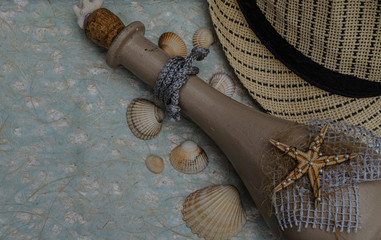 Seashells, decorative bottle, summer hat on a blue background.