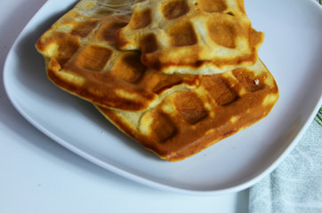 Homemade Belgium Waffles with fresh blueberries for breakfast. White plate, Viennese waffles with raspberries and mint. quick delicious breakfast on white background