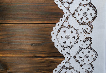 White lace handmade tablecloth on a wooden table on the right