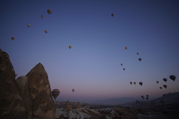 Hot air balloon flying over rock landscape at Cappadocia Turkey
