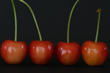 Ripe red cherries on black background.