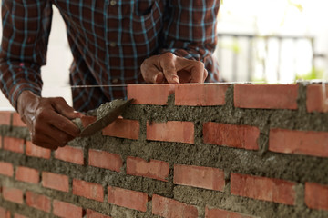 Bricklayer worker installing brick masonry