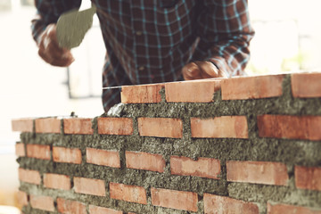 Bricklayer worker installing brick masonry