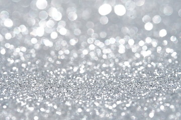 Silver Sparkling Lights Festive background with texture. Abstract Christmas twinkled bright bokeh...