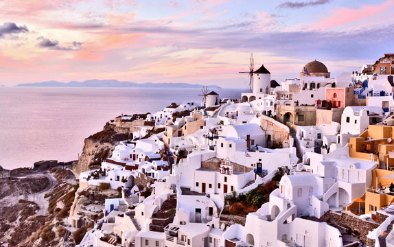 Oia village Thira Santorini Greece with sunset with pink and purple sky.