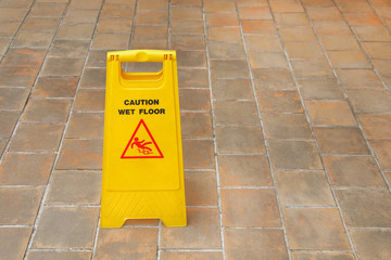 one yellow plastic wet floor sign on tile floor