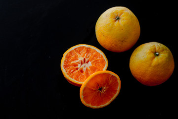 Fototapeta na wymiar minimal fruit composition for breakfast with orange with a black background