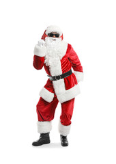 Cool African-American Santa Claus listening to music and dancing against white background