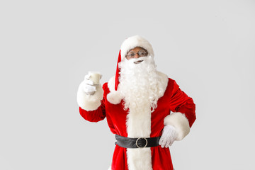 African-American Santa Claus with milk on light background