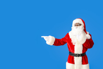 Fototapeta na wymiar African-American Santa Claus showing something on color background