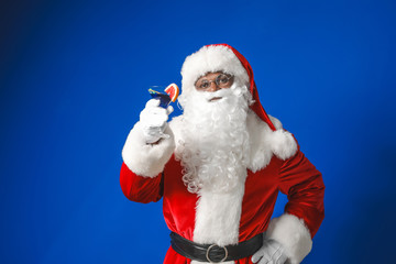 Fototapeta na wymiar African-American Santa Claus with cocktail on color background