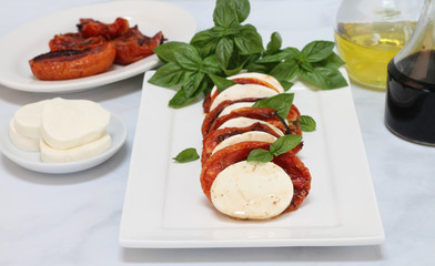 Caprese salad with roasted tomatoes, mozzarella and basil.
