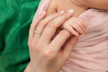 Fototapeta premium mom holds the hand of a newborn baby. Love and tenderness. Mothers Day.