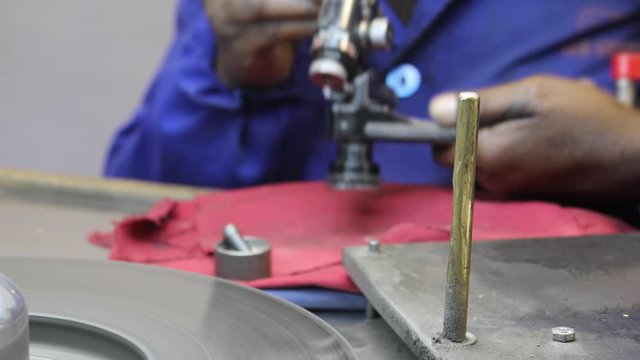 African woman working in a diamond polishing wheel machine