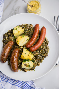 Oldenburger Gr&uuml;nkohl mit Pinkel, Kohlwurst, Senf und Kartoffeln auf Marmor Tisch