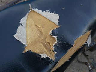 closeup of old and torn leather motorcycle seat.