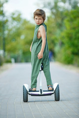 The child goes in for sports. A little boy is riding a hoverboard. High quality photo.