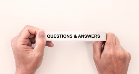 Businessman holding white sign with the message Q and A.