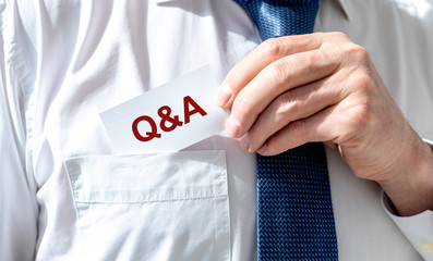 Businessman holding white sign with the message Q and A.
