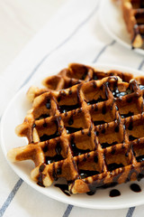 Yummy Homemade Belgian Sugar Waffles on a white plate on cloth, low angle view. Close-up.