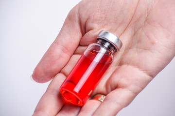 Woman hand with medical ampoule vial for infection. Corona virus infection, COVID-19, nCoV-2019 vaccine. Glass bottle with hand isolated on white background. 