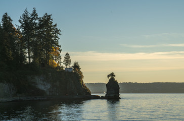 Sunset Siwash Rock at Stanley Park in Vancouver, Canada. It is largest urban park with beaches, trails, scenic seawall. Top attraction for tourist in Vancouver, British Columbia