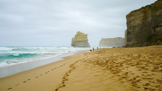 Twelve Apostles And People On Beach Near The Great Ocean Road In Victoria, Australia