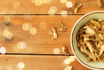 Fototapeta na wymiar culinary, food and cooking concept - dried mushrooms in bowl on wooden background