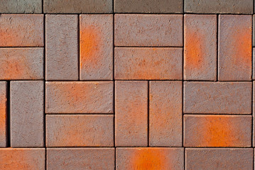Cobblestone texture. The sidewalk tile is evenly folded. Brown and orange cobblestones close up.