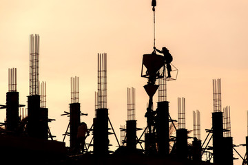Construction workers are casting columns to build buildings using cranes.