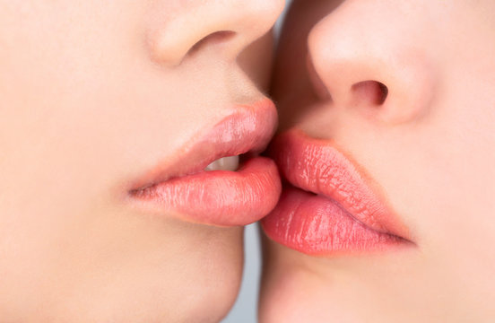 Closeup of women mouths kissing. Two beautiful sexy lesbians in love. Lip care and beauty. Closeup of beautiful young woman healthy lips. Lesbian couple kiss lips. Passion and sensual touch