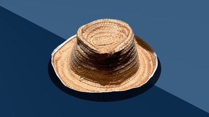 Fototapeta na wymiar straw hat for a farmer with a blue color background.