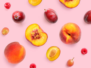 Creative layout made of grape, peach, plum and raspberry on the pink background. Flat lay. Food concept.	