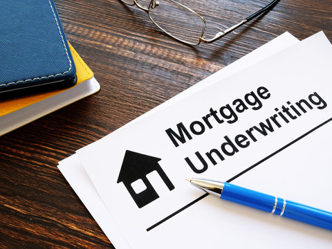 Information about mortgage underwriting and pen on the table.