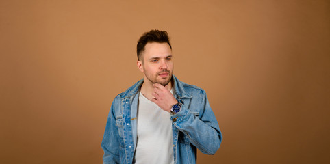 Handsome man standing and smiling isolated on light brown studio background. Male half-length portrait. The human emotions, facial expression concept. Front view.