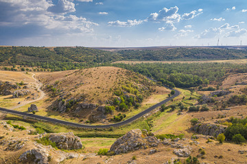 Aerial view over Dobrogei Gorges road and rock landscape from Constanta, Romania - amazing landmark with blue sky and white clouds