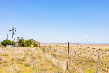 Fototapeta premium Windmill on a farm in rural grassland area of South Africa