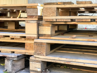 Stacked old used wooden pallets on street. Stacks of Euro-type cargo pallets. Background of wooden pallets. Furniture for installation and storage of goods