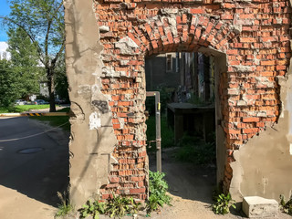 Old brick arch at entrance to house. Old door arch. Made at beginning of last century. Ruined brick arch without door. Broken arch in stone and brick building