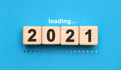 Loading 2021 years on wooden cubes on a blue background