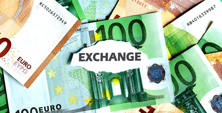 Focus on the word EXCHANGE , on piece of torn white paper with EUROS currency as a background.
