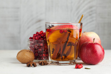 Autumn or winter food photo with hot tea with cinnamon, lemon, Apple, berries and spices. Copy space.