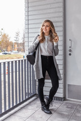 Fototapeta premium Portrait of stylish pretty young woman in autumn fashion walking in the city