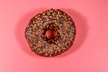 Tasty chocolate donut on a pink background
