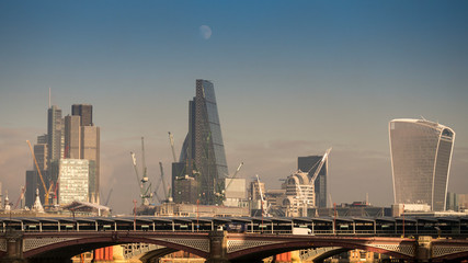 Fototapeta premium City of London, London, Britain. 20 January 2016. After another day of freezing temperatures in London a beautiful sunset ends the day, City of London with Moon Rise