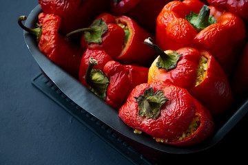 Cooked vegetarian stuffed peppers with rice and carrots in a baking dish. Home cooking. Close-up.