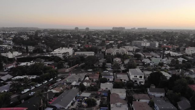 Aerial shot moving backwards over streets in Culver city neighborhood with downtown in background in Los Angeles, California, USA