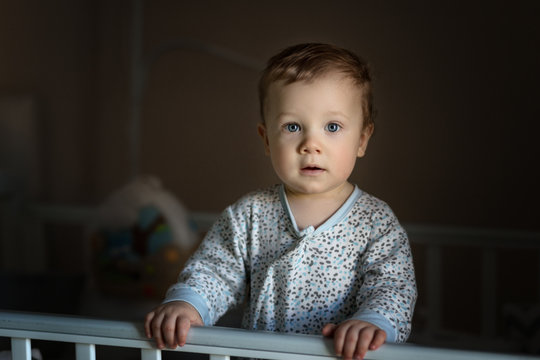 Cute Baby Boy Is Chewing A Cot Side