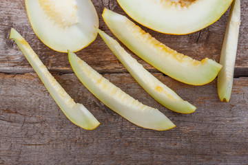 Sliced fresh sweet melon on a rustic wooden table. Top view