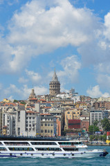 Fototapeta na wymiar Istanbul cityscape including historical Galata Tower, Boshphorus, passenger boats, and bridge 